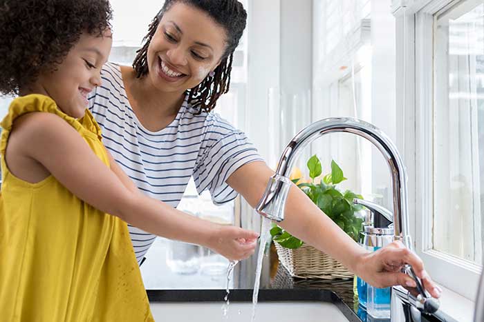 Mother and daughter washing hand near the sink